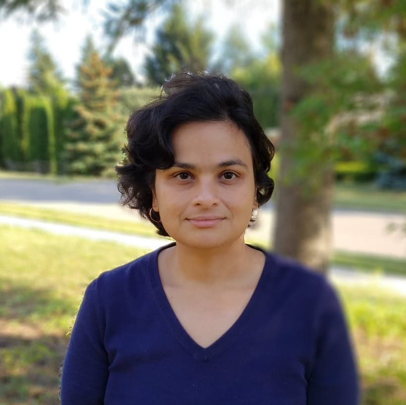 Ashirbani Photo of Dr. Ashirbani Saha wearing a dark blue shirt with tress behind her